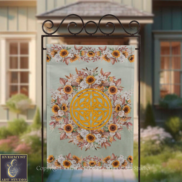 a banner with a floral design and a Celtic knot motif, hanging on a metal stand in front of a house.