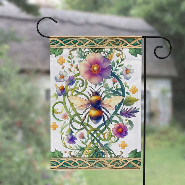 a garden flag hanging from a metal pole