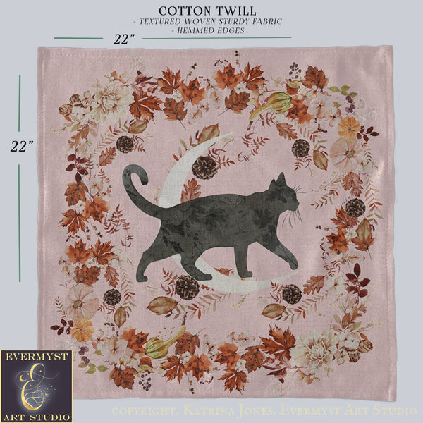 a square-shaped fabric with a black cat silhouette and a crescent moon design, surrounded by a wreath of autumn leaves and flowers.